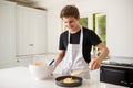 A Teenage Boy Cooking In A Kitchen