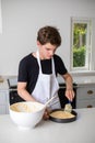 A Teenage Boy Cooking In A Kitchen