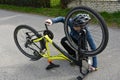 Boy squatting on the floor and checks his bike