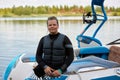 Teenage boy with disability sitting on boat outdoors