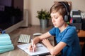 A teenage boy does homework, learns using a computer. Distance learning online. A child in quarantine in isolation Royalty Free Stock Photo