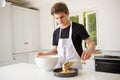 A Teenage Boy Cooking In A Kitchen