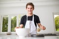 A Teenage Boy Cooking In A Kitchen