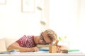 Teenage boy falling asleep while doing homework at table Royalty Free Stock Photo