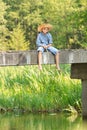 Teenage boy fishing with rod on bridge Royalty Free Stock Photo