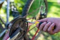 Teenage boy fixing hes bicycle with a screwdriver outdoor, shallow depth of field