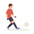 Teenage boy football player, in a red sports shirt, kicks a soccer ball. Kid sportsman playing football game, dynamic Royalty Free Stock Photo