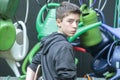 Teenage boy in front of hanging watering cans