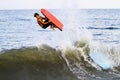 Teenage boy gets big air off the surf and waves at Bethany Beach Delaware Atlantic ocean.