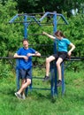 Teenage boy and girl exercising outdoors, sports ground in the yard, they posing at the horizontal bar, healthy lifestyle Royalty Free Stock Photo