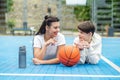 Teenage boy and girl are sitting on sports field, drinking water and talking during break Royalty Free Stock Photo