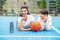 Teenage boy and girl are sitting on sports field, drinking water and talking during break Royalty Free Stock Photo