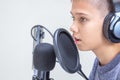 Teenage boy with headphones using microphone. Online learning, remote education, video game, podcast concept Royalty Free Stock Photo