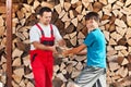 Teenage boy helping father stack the firewood