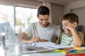 Teenage boy helping his younger brother doing homework