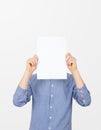 Teenage boy holding blank sheet of paper infront of his face. Man covering face with blank sheet of paper for hiding his identity Royalty Free Stock Photo