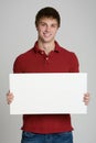 Teenage boy holding a blank sign isolated on white Royalty Free Stock Photo