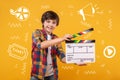 Teenage boy holding a clapstick and making an amateur film Royalty Free Stock Photo