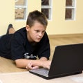 Teenage boy and laptop on floor Royalty Free Stock Photo