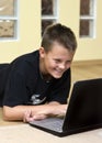 Teenage boy and laptop on floor Royalty Free Stock Photo