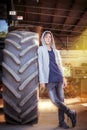 Teenage boy leaning against a huge tire