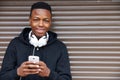 Teenage Boy Listening To Music And Using Phone In Urban Setting Royalty Free Stock Photo