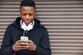 Teenage Boy Listening To Music And Using Phone In Urban Setting Royalty Free Stock Photo