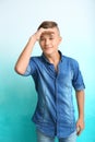 Teenage boy looking faraway on color background