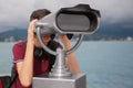 Teenage boy looking through mounted binoculars near sea, closeup. Space for text Royalty Free Stock Photo