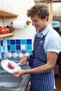 Teenage Boy With Part Time Job Washing Up In Coffee Shop Royalty Free Stock Photo