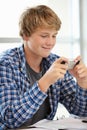 Teenage boy with phone in class Royalty Free Stock Photo