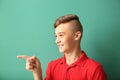 Teenage boy pointing at something on color background Royalty Free Stock Photo