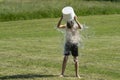 Teenage boy pouring bucket of cold water over his head outdoors. Ice water challenge. Cold water therapy benefits Royalty Free Stock Photo