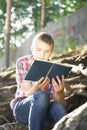 Teenage boy reading exercise book on the nature