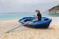 Teenage boy rowing in boat on greek beach Royalty Free Stock Photo