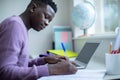 Teenage Boy Sitting At Desk Doing Homework Assignment On Laptop Royalty Free Stock Photo