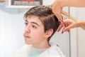 Teenage boy sitting at the hairdresser salon for a haircut