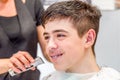 Teenage boy sitting at the hairdresser salon for a haircut