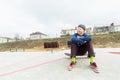 A teenage boy is sitting on a skateboard in the park and smiling. The concept of free time pastime for teenagers in the Royalty Free Stock Photo