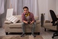 Teenage boy sitting on sofa playing computer games.