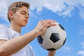 Teenage boy with a soccer ball on a of blue sky