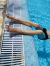 Teenage boy sunbathing at blue swimming pool on vacation in summer season Royalty Free Stock Photo