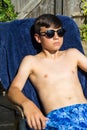 Teenage boy sunbathing in the garden Royalty Free Stock Photo