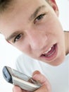 Teenage boy using cellular phone and looking mad Royalty Free Stock Photo