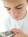 Teenage boy using cellular phone and smiling Royalty Free Stock Photo