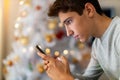 Teenage boy using mobile phone at home in Christmas time Royalty Free Stock Photo