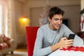 Teenage boy using mobile phone at home in Christmas time Royalty Free Stock Photo