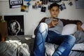 Teenage boy using smartphone in a bedroom social media concept