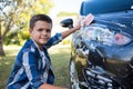 Teenage boy washing a car on a sunny day Royalty Free Stock Photo