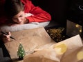 Teenage boy writing long letter to Santa Royalty Free Stock Photo